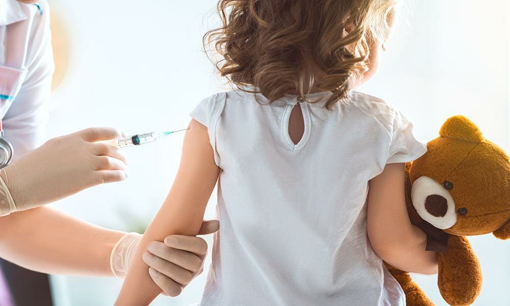A child receives a flu vaccine from a doctor.