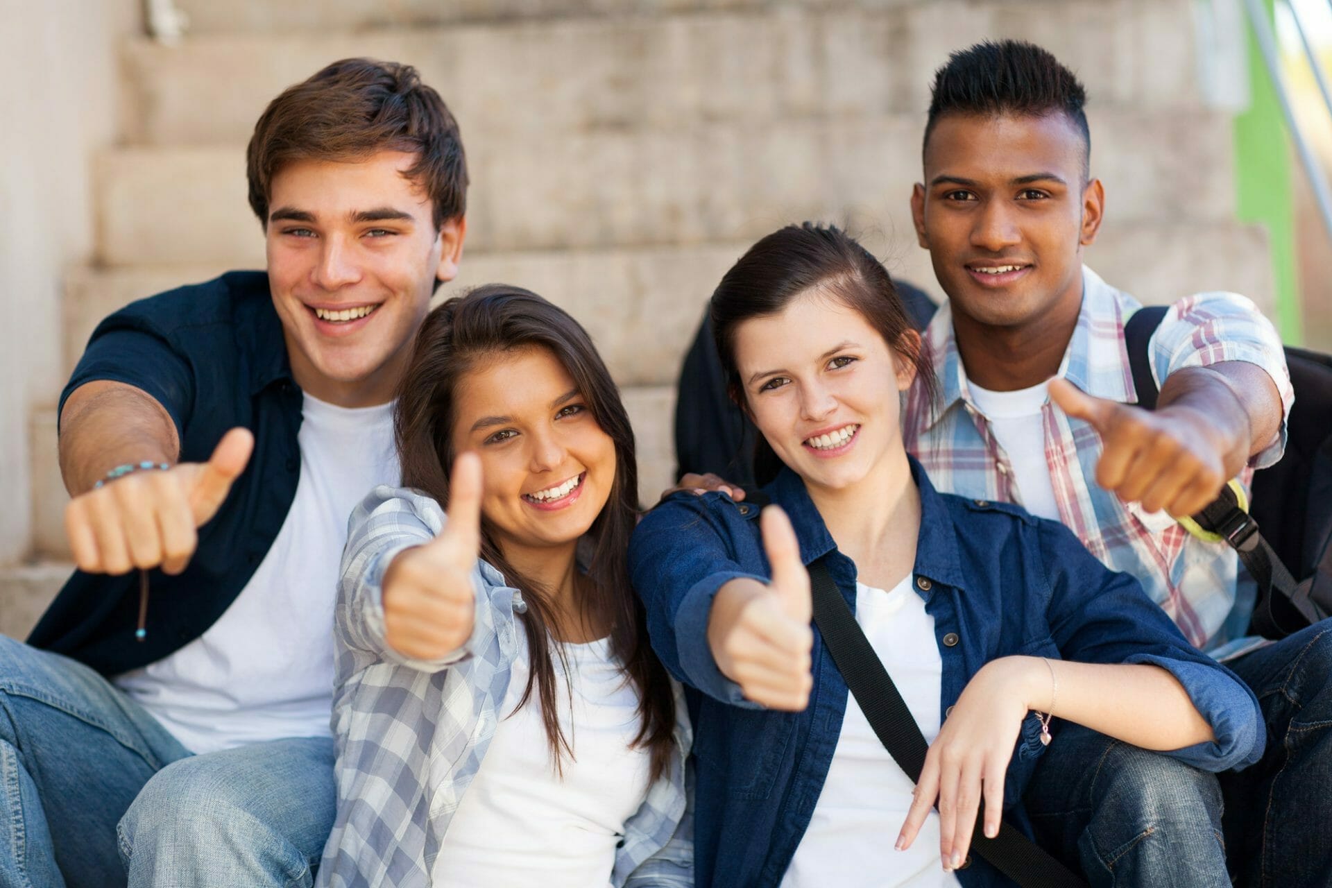 A group of young people giving thumbs up.