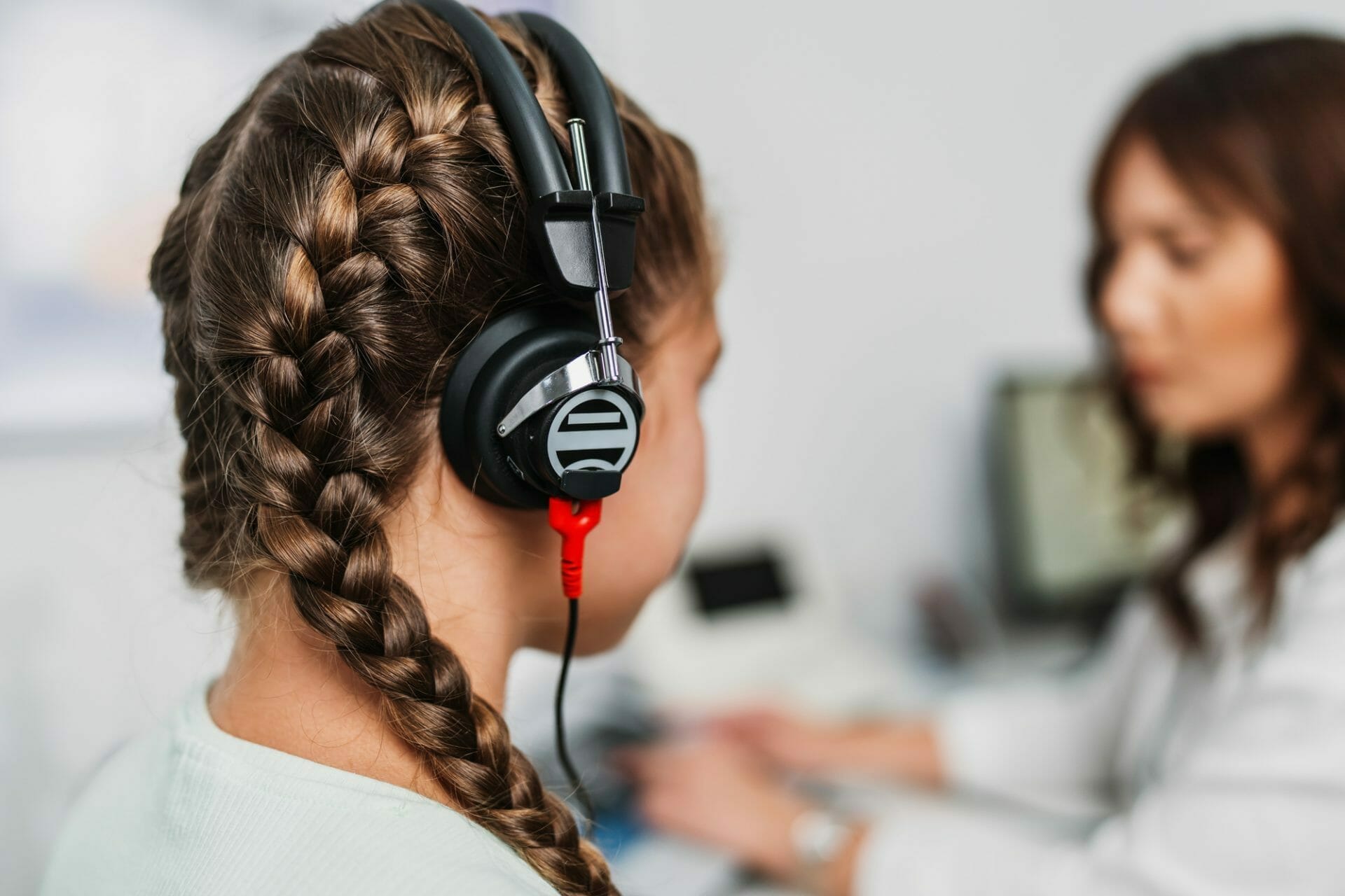 A young girl wearing headphones in a doctor's office.