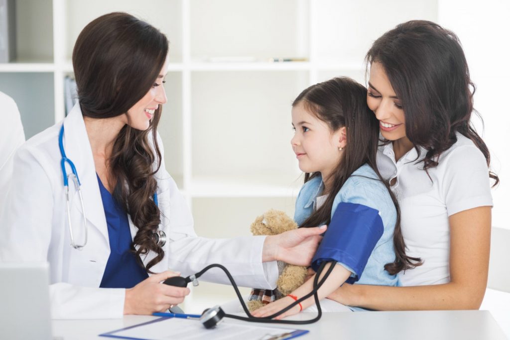 A Pediatrician is taking a child's blood pressure.