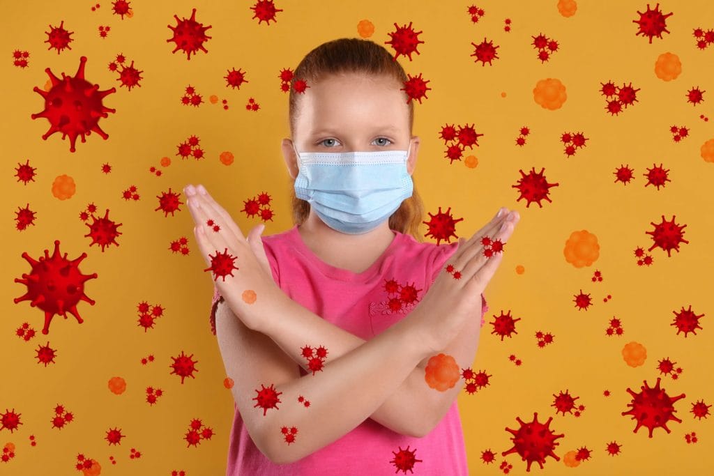A girl wearing a surgical mask to protect against deadly diseases, including the coronavirus, on a yellow background.